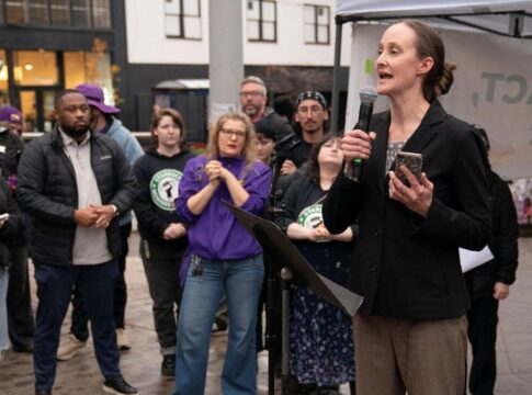 Mulher falando em palanque para outros trabalhadores do sindicato