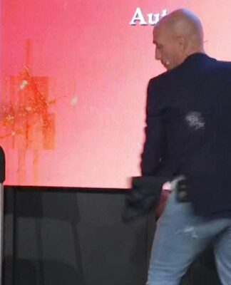 Luis Rubiales esquivando de uma ovada; a parede ao fundo já mostra pelo menos dois ovos quebrados