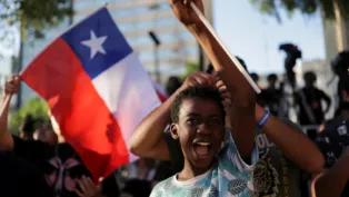 Garoto em manifestação, com bandeira do Chile ao fundo
