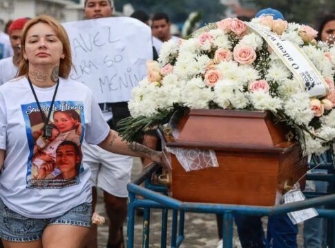 Mulher lidera cortejo fúnebre ao lado do caixão do marido