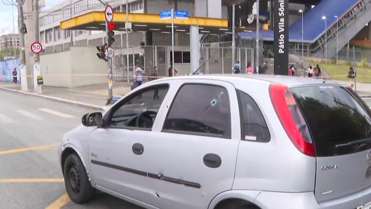 imagem de veículo com marcas de tiros parado no meio de uma avenida