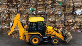 Trator carrega pilhas de lixo reciclado
