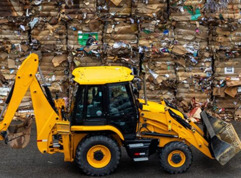 Trator carrega pilhas de lixo reciclado