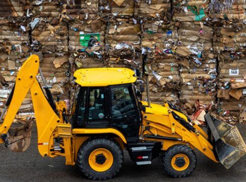 Trator carrega pilhas de lixo reciclado