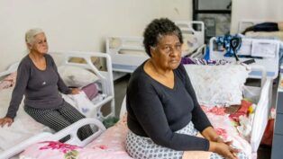 Duas idosas estão sentadas em leitos