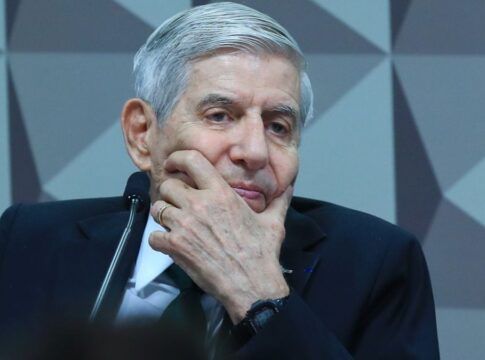 O general Augusto Heleno apoia o rosto com a mão enquanto participa de sessão no Congresso, diante do microfone