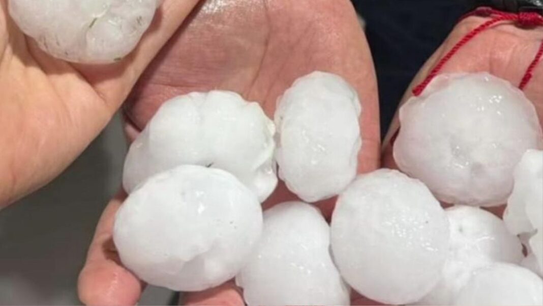 Imagem mostra pedras grandes de granizo em duas mãos