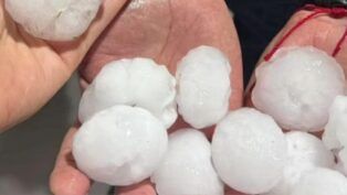 Imagem mostra pedras grandes de granizo em duas mãos