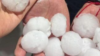 Imagem mostra pedras grandes de granizo em duas mãos