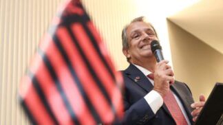 Bap discursa ao lado da bandeira do Flamengo