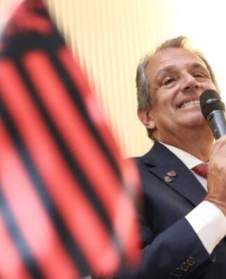 Bap discursa ao lado da bandeira do Flamengo