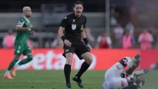 Árbitro Ramon Abetti Abel de pé, ao lado de um jogador do São Paulo no chão, durante partida contra o Palmeiras