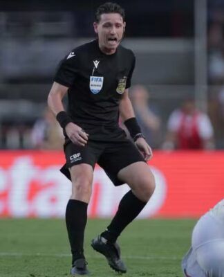 Árbitro Ramon Abetti Abel de pé, ao lado de um jogador do São Paulo no chão, durante partida contra o Palmeiras