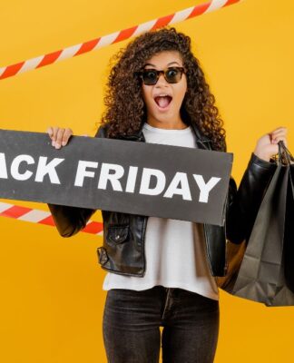 Mulher em fundo amarelo, segurando sacolas pretas e placa escrita black friday
