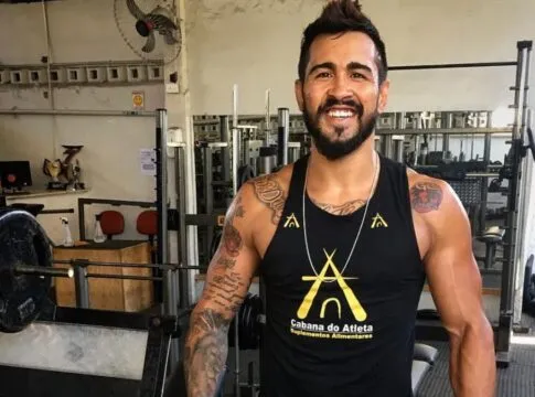 Godofredo Pepey aparece de camisa regata no meio de uma academia de musculação