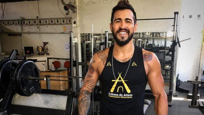 Godofredo Pepey aparece de camisa regata no meio de uma academia de musculação