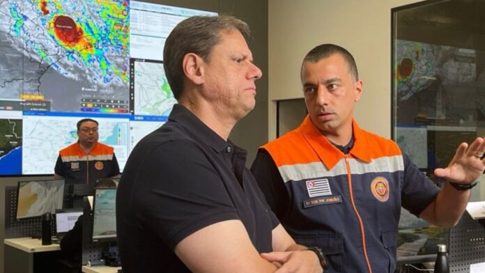 Governador Tarcísio e um funcionário da Defesa Civil conversando no gabinete