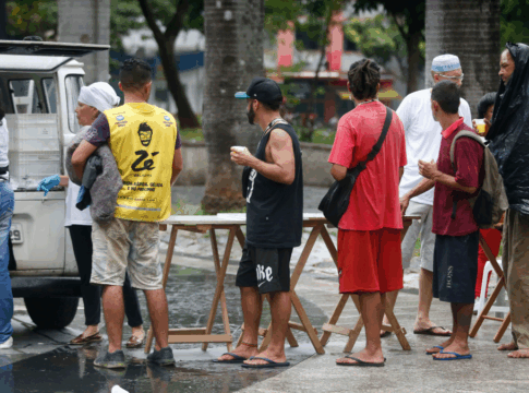 Moradores de rua recebem comida na Sé em SP.