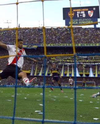 Merentiel, do Boca Juniors, se jogando no gramado para marcar o gol da equipe contra o River Plate.