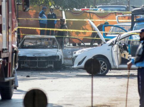 Carro destruído por explosão cercado por fita de isolamento