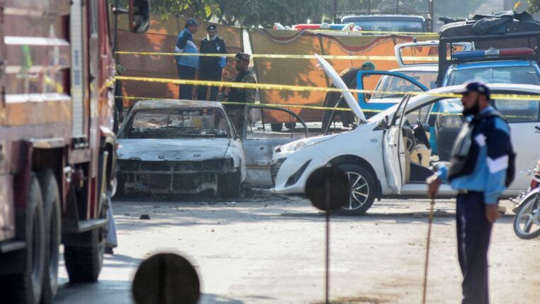 Carro destruído por explosão cercado por fita de isolamento