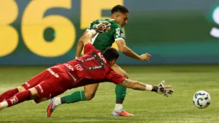Vitor Roque, atacante do Palmeiras, enquanto dribla o goleiro Brazão, do Santos, para marcar seu primeiro gol na partida entre as equipes.