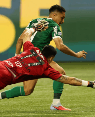 Vitor Roque, atacante do Palmeiras, enquanto dribla o goleiro Brazão, do Santos, para marcar seu primeiro gol na partida entre as equipes.