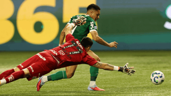 Vitor Roque, atacante do Palmeiras, enquanto dribla o goleiro Brazão, do Santos, para marcar seu primeiro gol na partida entre as equipes.