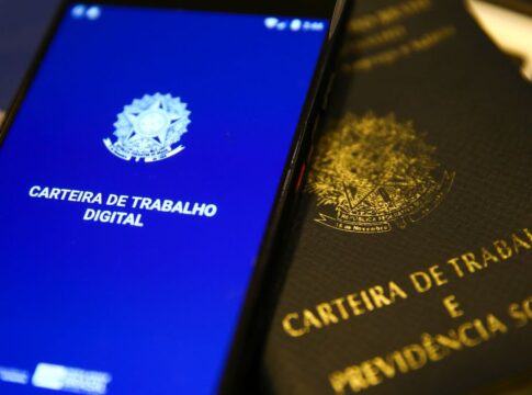 Imagens da carteira de trabalho tradicional e também da versão online na tela de um celular