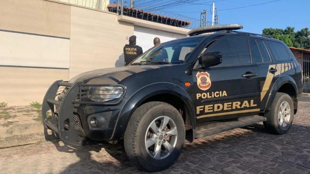 Carro da Polícia Federal está estacionado em frente a uma casa