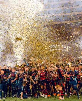 Jogadores do Flamengo festejam o tetracampeonato da Libertadores em meio a chuva de papel picado no gramado.