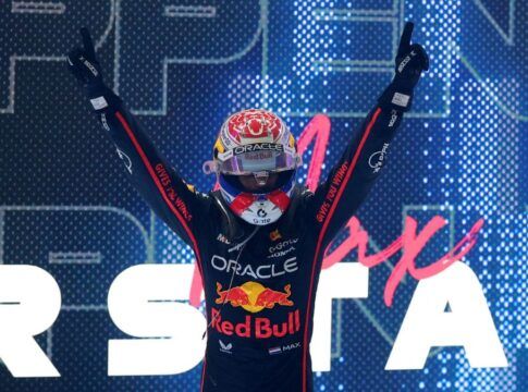 Max Verstappen, de capacete, comemora vitória à frente de telão com o seu nome