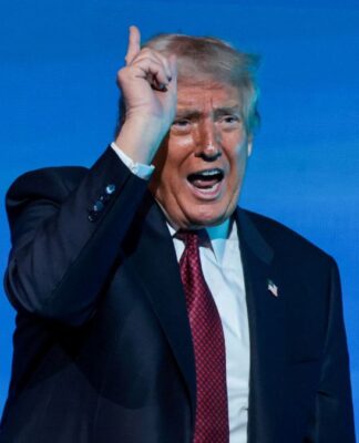 Donald Trump falando durante discurso, apontando para cima