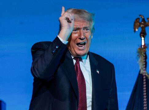 Donald Trump falando durante discurso, apontando para cima