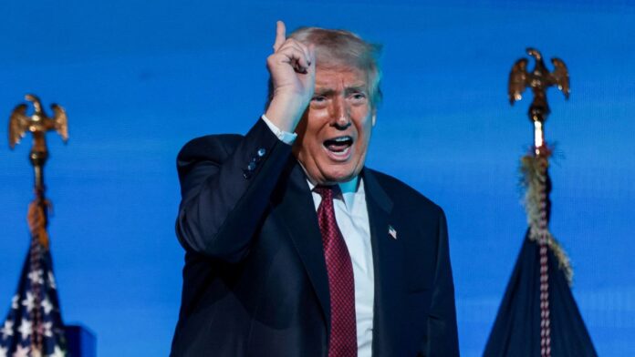 Donald Trump falando durante discurso, apontando para cima