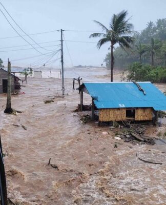 Cidade completamenta alagada nas Filiinas. Casa de madeira com água quase até o telhado, em meio de toda a água.
