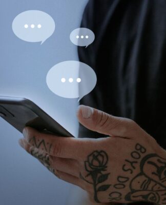 Homem segurando smartphone; balões transparentes contendo três pontinhos saem da tela