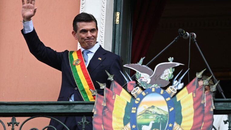 Rodrigo Paz com faixa presidencial na sacada, acenando para população boliviana