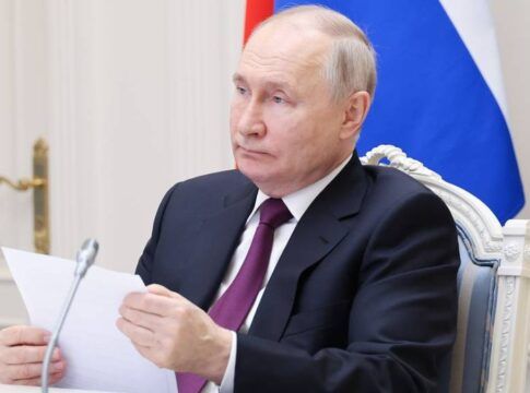 O presidente Vladimir Putin segura uma folha de papel diante do microfone