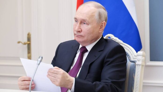 O presidente Vladimir Putin segura uma folha de papel diante do microfone