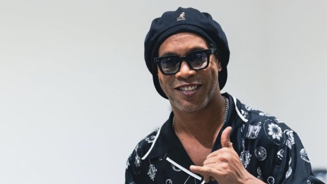 Ronaldinho Gaúcho posando para foto fazendo sinal de 