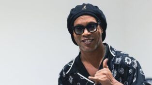 Ronaldinho Gaúcho posando para foto fazendo sinal de "hang loose"