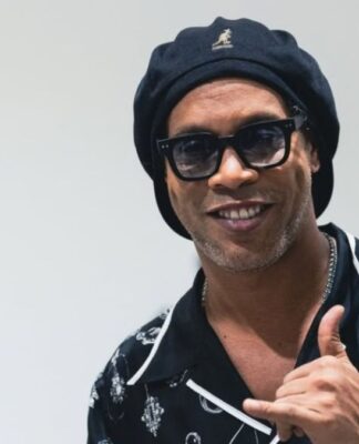Ronaldinho Gaúcho posando para foto fazendo sinal de 