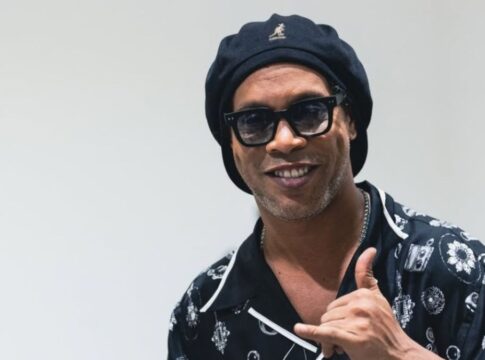 Ronaldinho Gaúcho posando para foto fazendo sinal de 