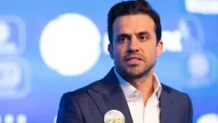 Pablo Maçal vestido de terno e seu número de candidato colado no terno.