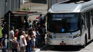 Fila de pessoas à espera do ônibus, ao lado