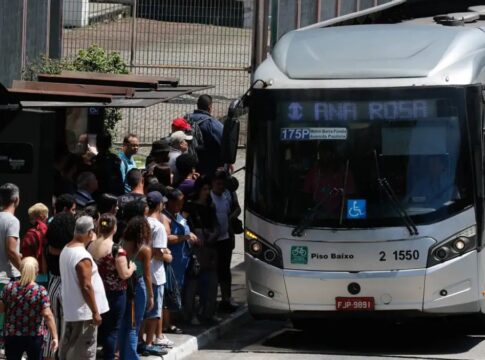 Fila de pessoas à espera do ônibus, ao lado