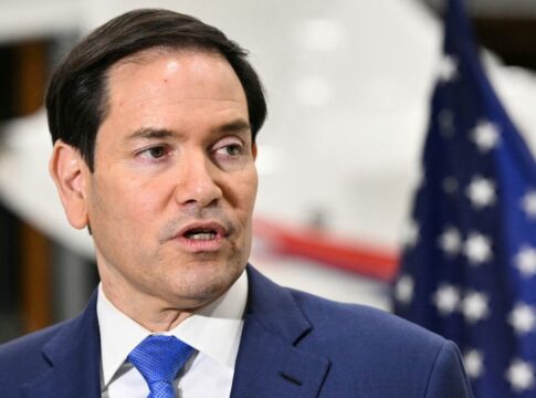 Marco Rubio fala aos repórteres com bandeira dos EUA ao fundo