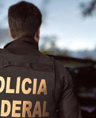 Agente, de costas, apresenta a inscrição polícia federal em seu uniforme