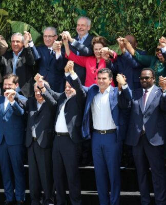 Delegados de vários países, com as mãos dadas e erguidas, posando para foto oficial da COP30
